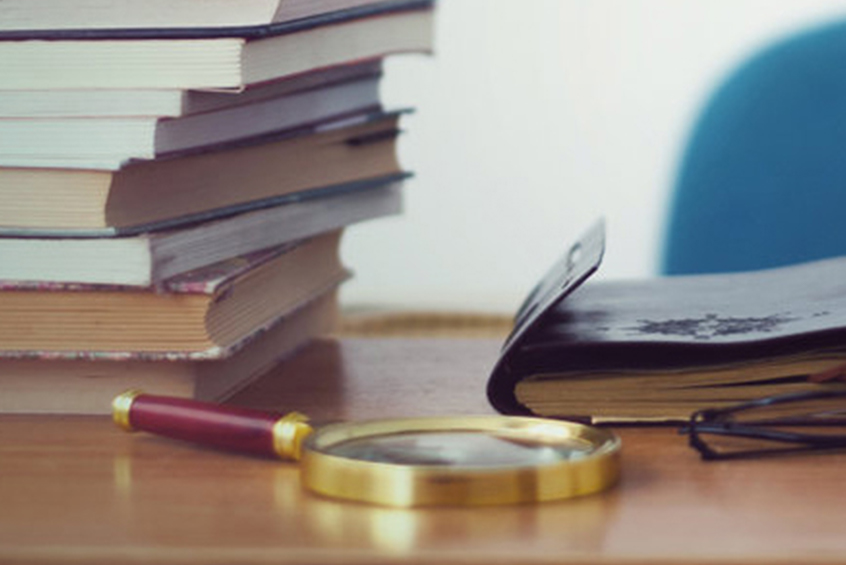 Cos'è l'IPB? libri e lente di ingrandimento sopra un tavolo